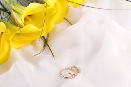 yellow flowers and wedding rings の写真素材