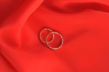 wedding rings on red backgroundの写真素材