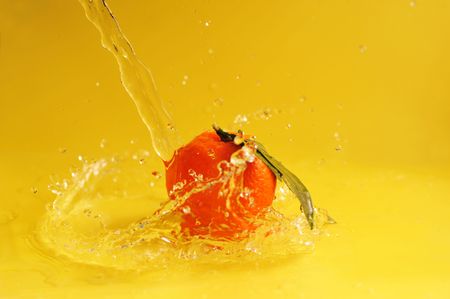 tangerine and water splashes on yellow, close upの写真素材