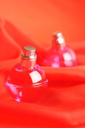  two bottles of perfume, isolated on red close upの写真素材