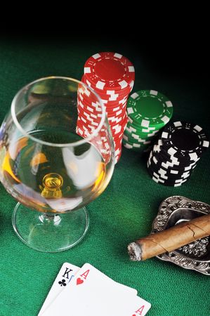 Cigar, chips for gamblings, drink and playing cards on greenの写真素材