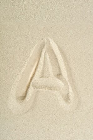 letter written on sea sand close upの写真素材