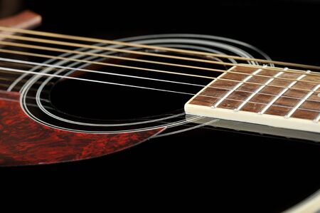 Detail of an acoustic black guitar with the strings and the sound holeの写真素材