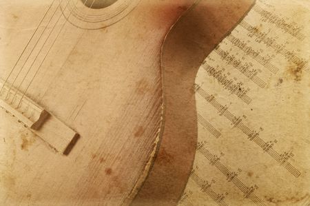 Acoustic guitar laying across sheet musicの写真素材