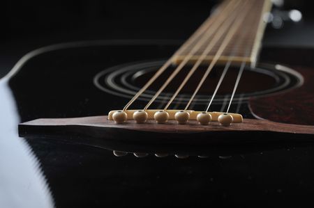 Detail of an acoustic black guitar with the strings and the sound holeの写真素材