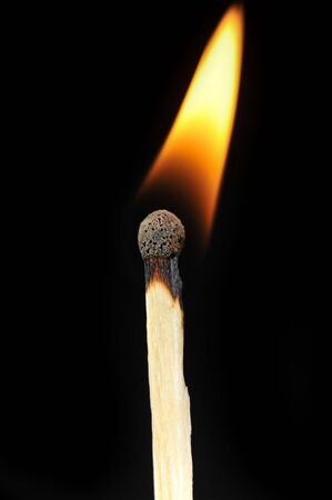  ignited matchstick flame in dark close upの写真素材