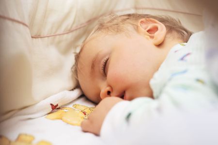 Cute baby sleeping in bedの写真素材