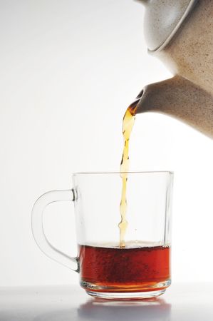 Full glass cup of tea and teapotの写真素材