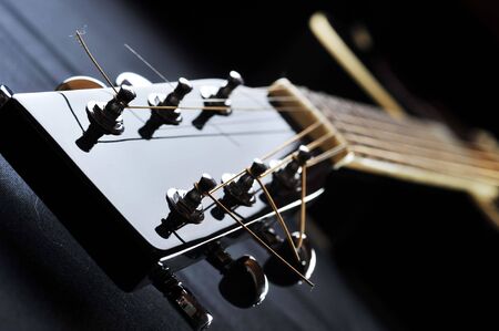 Details of  acoustic black guitar. neck, nut, frets, strings.
