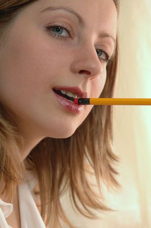 young woman with pencil in hers lipsの写真素材