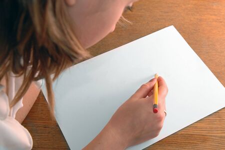 young woman with pencil writing on paperの写真素材