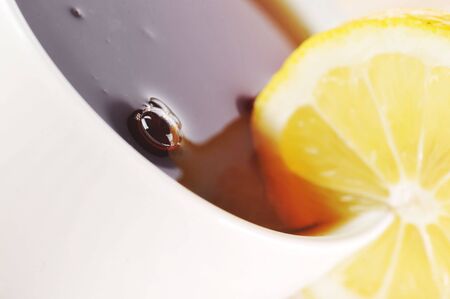 On  wooden napkin full cup of tea with lemon
