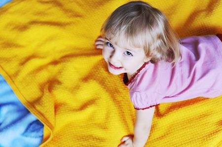 Beautiful little girl  lying on  bed at  houseの写真素材