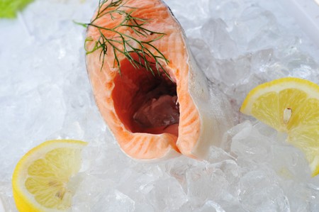 pieces of red fish and lemon  on ice 