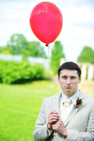 young groom  with balloon  on  green fieldの写真素材