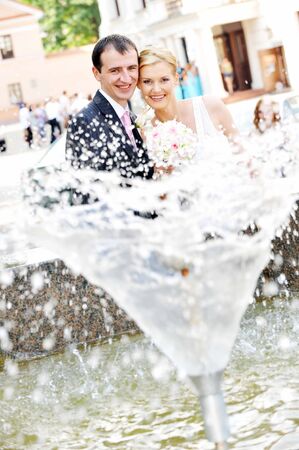 bride and groom stand near  fountainの写真素材