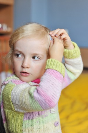 cheerful little girl sits on bed of parentsの写真素材