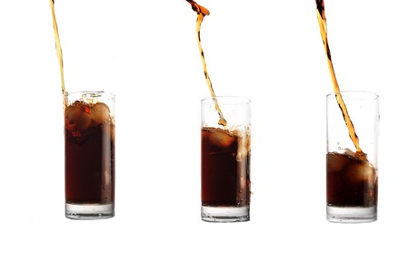 cola pour into glass on white backgroundの写真素材