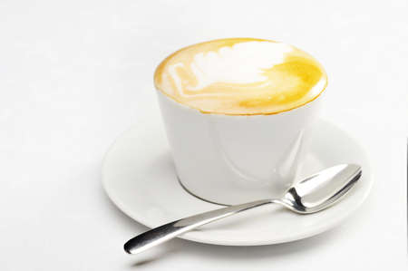 White cup of cappuccino with brown and white foam on top. Object  on white