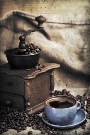 Vintage manual coffee grinder with coffee beans and cupの写真素材