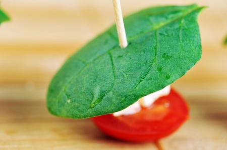 delicious sandwich  on skewer with tomatoes, spinach and cheeseの写真素材