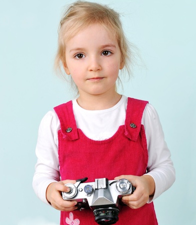  lovely blond little girl play with old retro cameraの写真素材