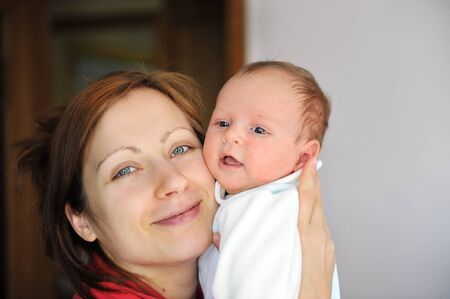 Adorable little baby in arms of his mom.の写真素材