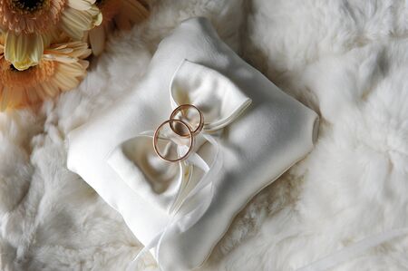bride bouquet of yellow flowers and cushion with wedding  gold rings 
の写真素材