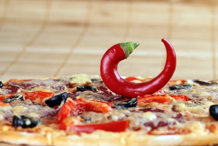  pizza with tomatoes, cheese, black olives and chili pepperの写真素材