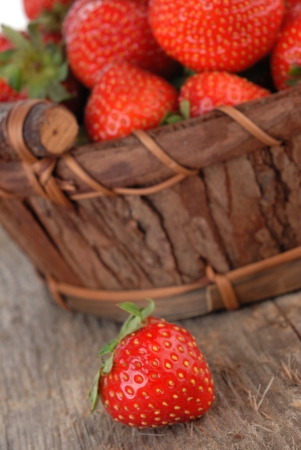 Basket of fresh strawberries on wooden boardの写真素材