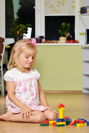 cute blond girl  playing with cubes at home  の写真素材