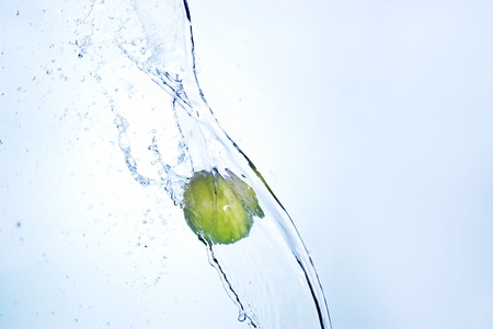 Green apple in splash of water isolatedの写真素材