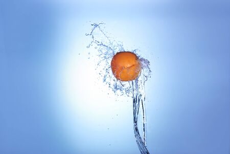 big orange in splash of water isolatedの写真素材