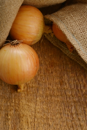 Open jute sack with ripe onions  on wooden boardの写真素材