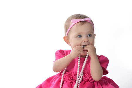 Adorable little baby girl  in  pink dress sitting on floorの写真素材
