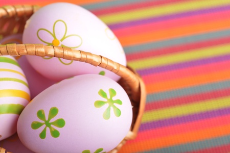 basket wicker with decoration easter eggs on striped napkin の写真素材