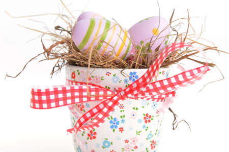  painted easter eggs on green in decorative bowlの写真素材