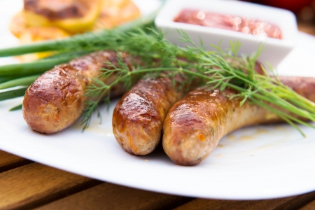 tasty grilled meat sausages on dishの写真素材