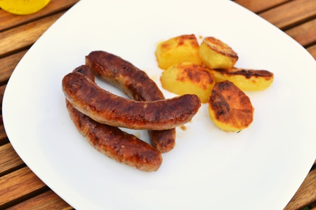 tasty grilled meat sausages on dishの写真素材
