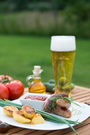 tasty grilled meat sausages  on dish and vegetableの写真素材