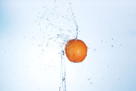 big orange in splash of water isolatedの写真素材