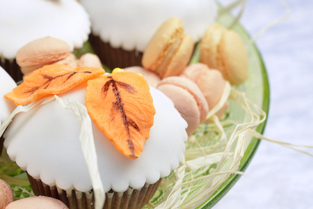 cupcakes with white icing, decorated with autumn leavesの写真素材