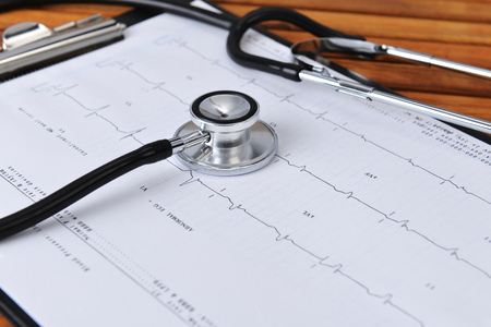 stethoscope on printout of heart monitor -blue tint on wooden backgroundの写真素材