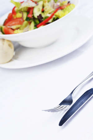 salad of fresh vegetable with bun on white dish.の写真素材