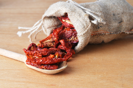 Dried tomatoes got enough sleep from canvas bag at wooden backgroundの写真素材