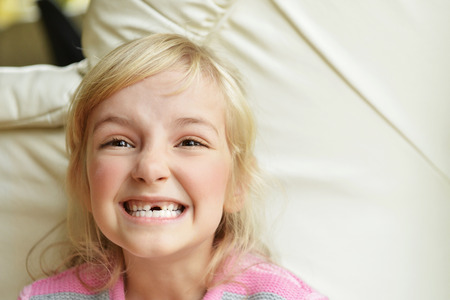 happy girl at home on white sofa