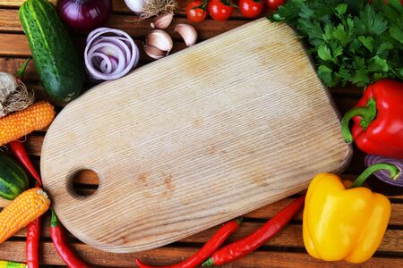 fresh vegetables and cutting board on wooden backgroundの写真素材