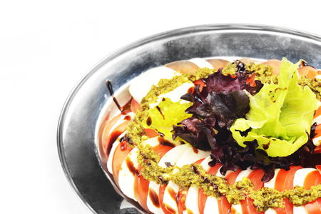 sliced of tomato and mozzarella with souse on dish. Insalata capreseの写真素材