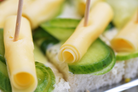 Sandwich with cheese and cucumber on wooden chopsticksの写真素材