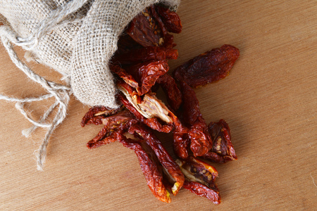 Dried tomatoes got enough sleep from canvas bag at wooden backgroundの写真素材